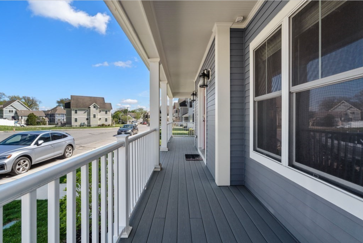 Side porch with white railings with balusters.