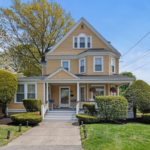 Daisy-yellow Victorian with front porch and white trim.