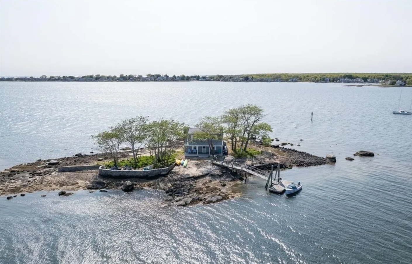 Blue single-family home with white trim, front porch, and 0.27-acre island lot.