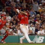 Rafael Devers #11 of the Boston Red Sox follows through on his go-ahead RBI-double during the eighth inning