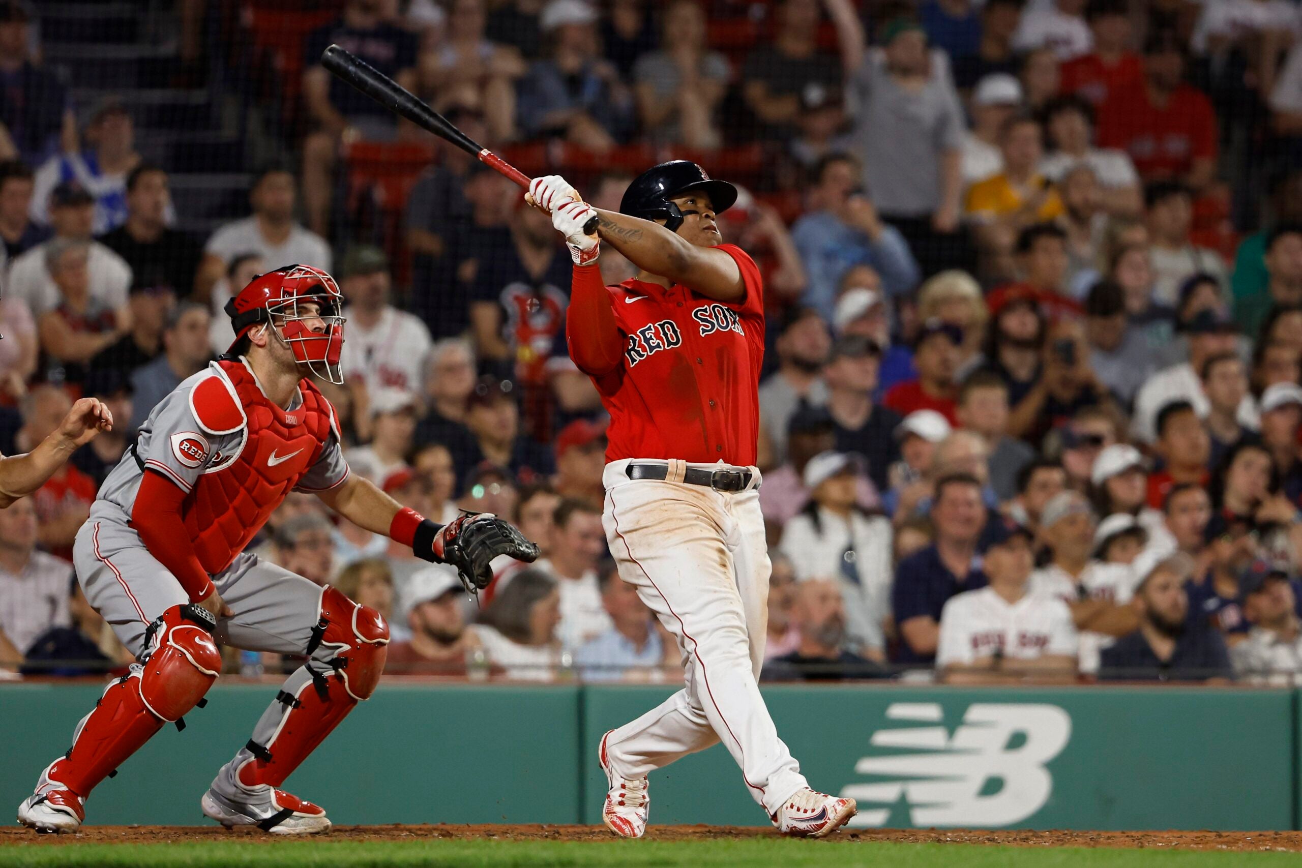 Rafael Devers #11 of the Boston Red Sox follows through on his go-ahead RBI-double during the eighth inning