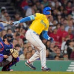 Boston Red Sox Triston Casas, right, follows through on his swing after hitting a two-run ground rule double in front of New York Yankees' Kyle Higashioka, left, allowing Jarren Duran and Alex Verdugo to score in the fifth inning of the second game of a baseball doubleheader, Sunday, June 18, 2023, in Boston.