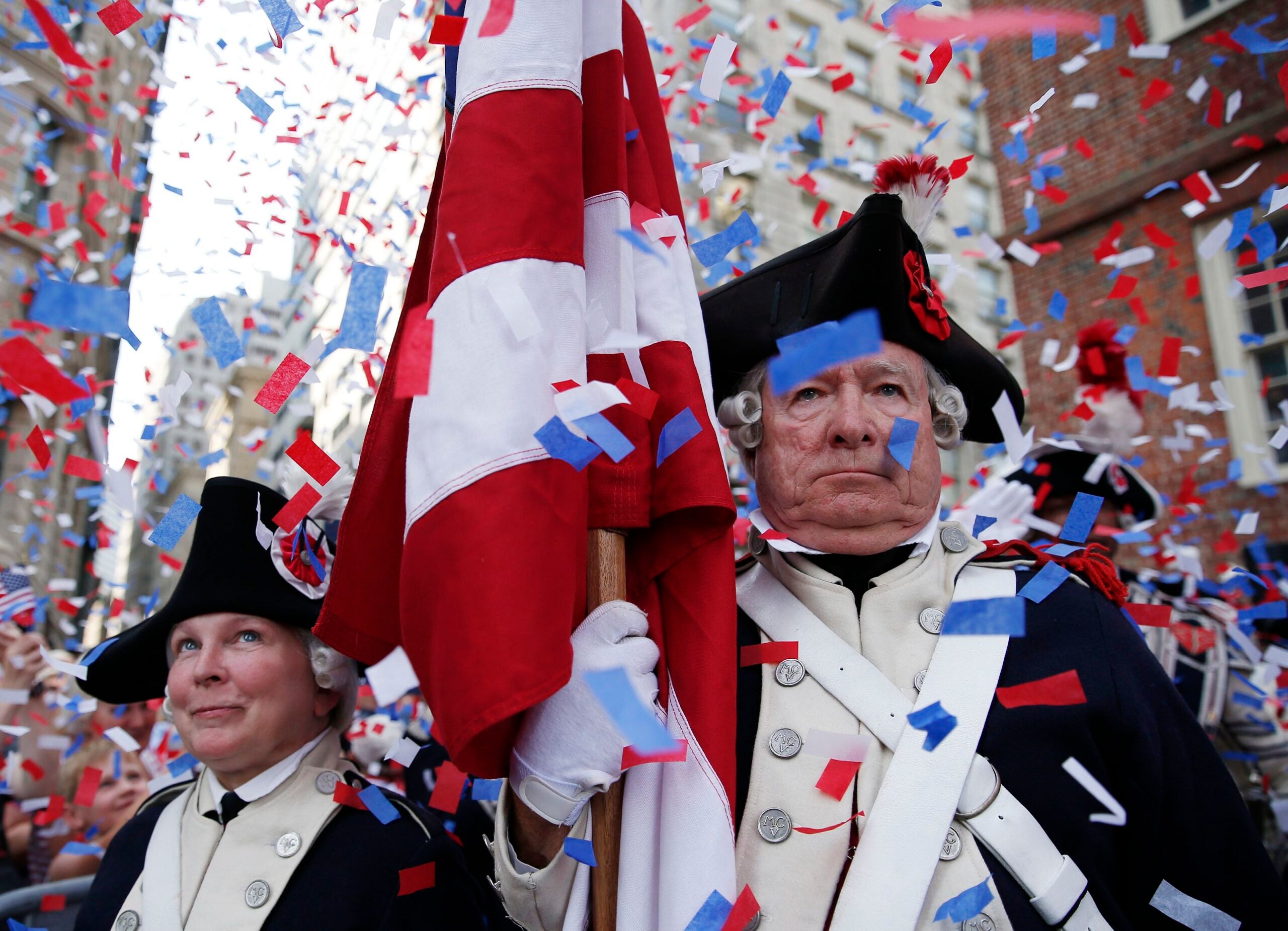 Members of the Middlesex County Volunteers fifes & drums watch as confetti falls after the reading of Declaration of Independence at the Old State House.