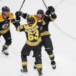 Boston Bruins left wing Brad Marchand (63) and Boston Bruins left wing Tyler Bertuzzi (59) and Boston Bruins right wing David Pastrnak (88) celebrate after Marchand;s game tying goal during the second period.