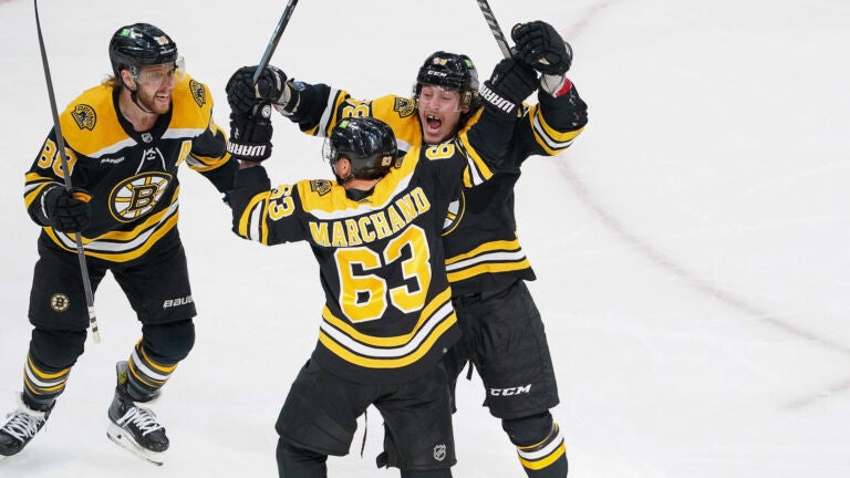 Boston Bruins left wing Brad Marchand (63) and Boston Bruins left wing Tyler Bertuzzi (59) and Boston Bruins right wing David Pastrnak (88) celebrate after Marchand;s game tying goal during the second period.