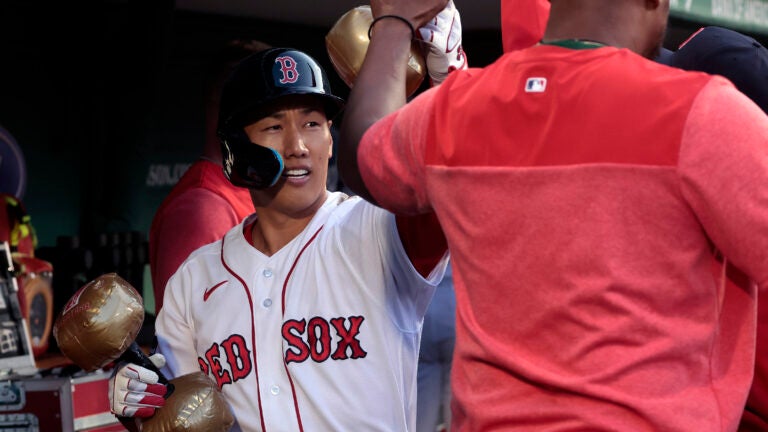 Boston Red Sox designated hitter Masataka Yoshida (7) with the celebratory inflatable dumbbells in the dugout following his solo home run in the second inning.