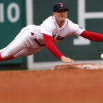 Kiké Hernández dives to his left near the second-base bag, but a ground ball gets under his glove.