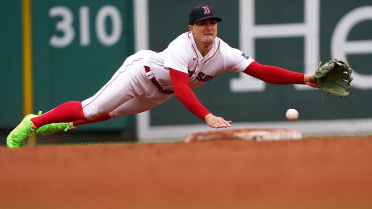 Kiké Hernández dives to his left near the second-base bag, but a ground ball gets under his glove.