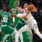 Boston Celtics defenders surround Denver Nuggets center Nikola Jokic (15) during the first quarter.