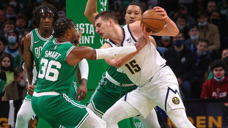 Boston Celtics defenders surround Denver Nuggets center Nikola Jokic (15) during the first quarter.