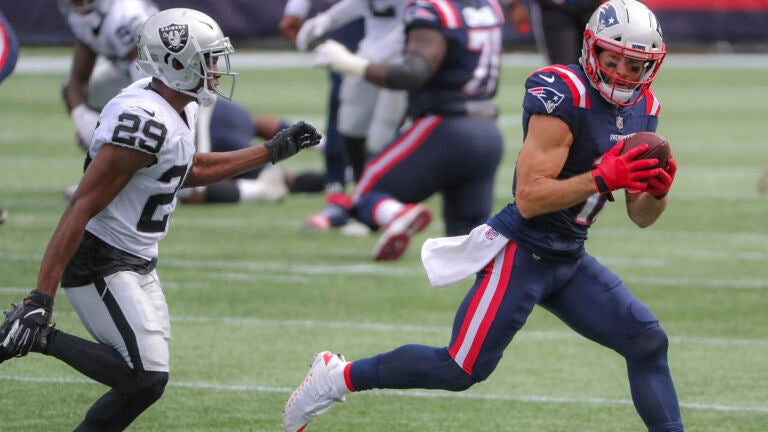 New England Patriots Julian Edelman hauls in a 15 yard reception in front of Las Vegas Raiders Lemarus Joyner during second quarter action at Gillette Stadium.