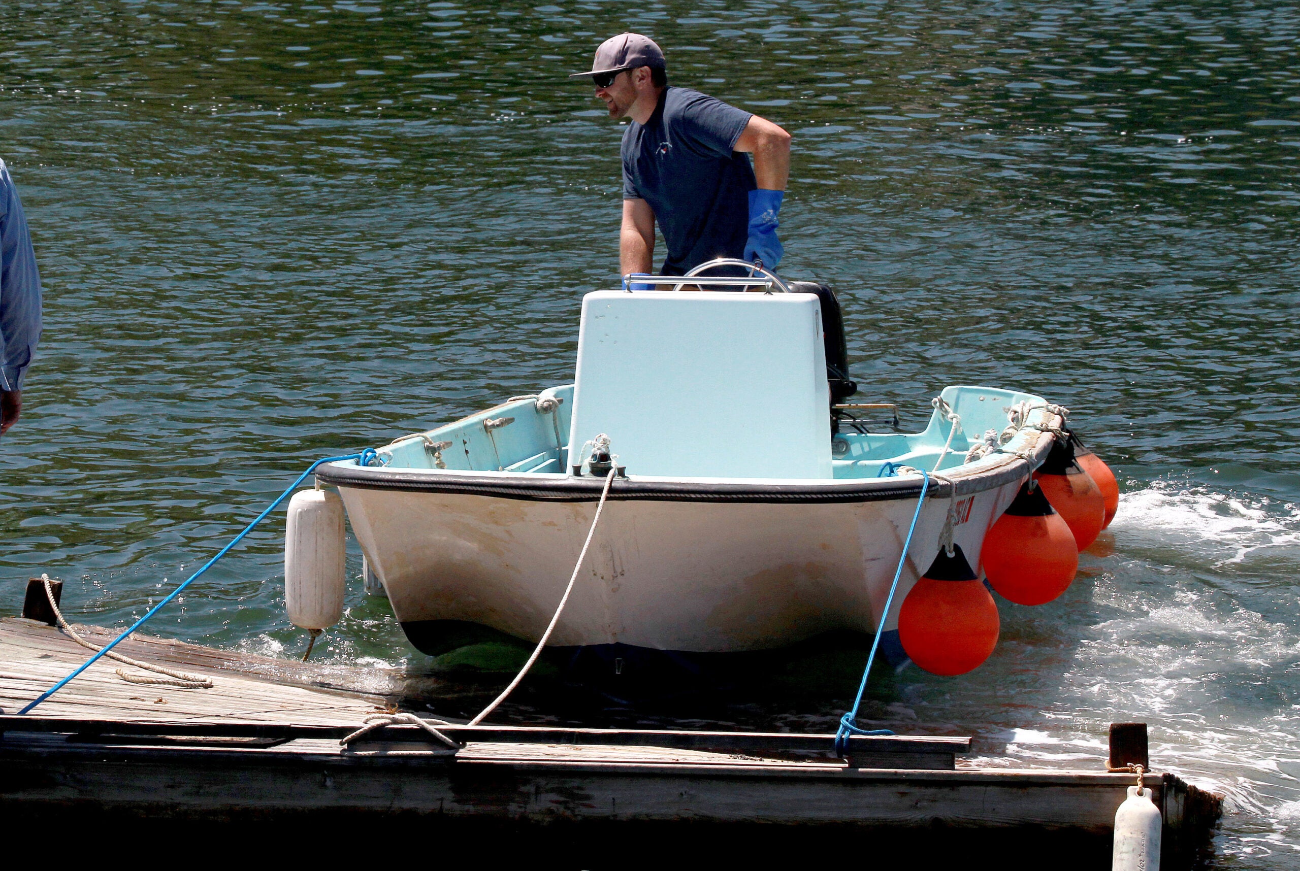 Nate Cunningham, waterfront manager of the Annisquam Yacht Club, uses the club's workskiff, a 1960 Boston Whatler, to move a float in Lobster Cove in Gloucester, Mass. 