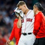 Boston Red Sox starting pitcher Tanner Houck (89) is helped off the field after getting hurt during the game between the Boston Red Sox and the New York Yankees at Fenway Park on Friday.