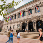 People walk up the steps to the Boston Public Library in Copley Square. Pride flags are seen on the building.