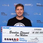 Powerball winner Brendan Stewart holds check for $1 million.