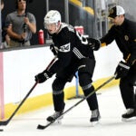 Defenseman Mason Lohrei, left, works with coaching staff during the first day of Bruins development camp at Warrior Arena.