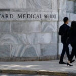 FILE - Pedestrians walk towards the Harvard Medical School, Aug. 18, 2022.