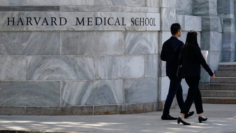 FILE – Pedestrians walk toward Harvard Medical School, August 18, 2022.