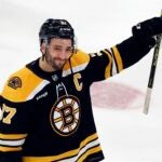 Boston Bruins' Patrice Bergeron raises his stick to the fans after losing to the Florida Panthers in overtime during Game 7 of an NHL hockey Stanley Cup first-round playoff series, Sunday, April 30, 2023, in Boston. Bruins forward Patrice Bergeron has retired. The five-time Selke Trophy winner announced Tuesday, July 25, 2023, that he will not return for a 20th season with the only team he has ever played for. The Bruins captain said he is leaving with no regrets.