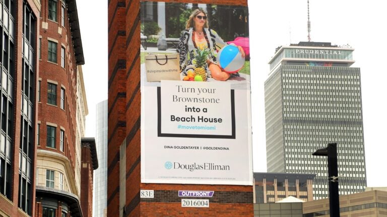 billboard suggests Bostonians move to Miami (climate change and economic policies)