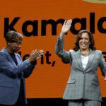 Vice President Kamala Harris greets the audience as moderator and Massachusetts Attorney General Andrea Campbell applauds at the 114th National Association for the Advancement of Colored People's national convention.