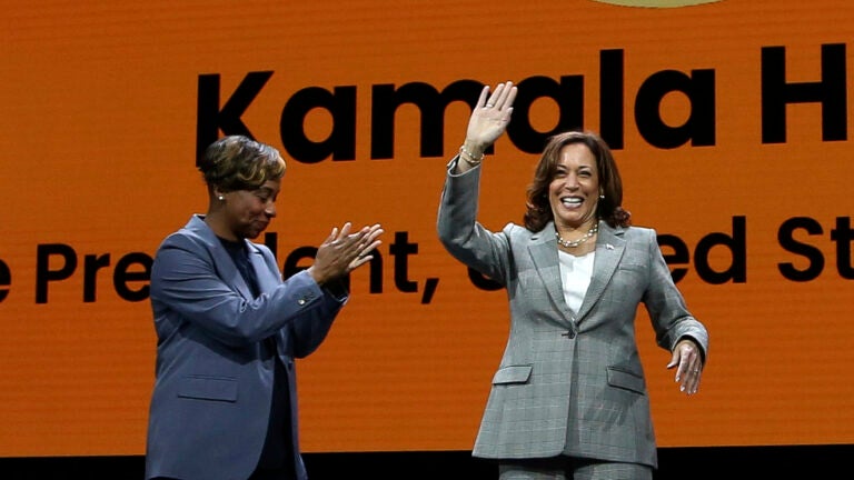 Vice President Kamala Harris greets the audience as moderator and Massachusetts Attorney General Andrea Campbell applauds at the 114th National Association for the Advancement of Colored People's national convention.