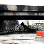 Workers inspect and clear debris from a section of the bridge that collapsed on Interstate 95 after an oil tanker explosion on June 12, 2023, in Philadelphia.