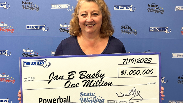 Powerball winner Jan Busby holds $1 million check.