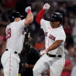 Boston Red Sox's Rafael Devers, right, celebrates with Adam Duvall, left, after scoring on his home run in the seventh inning of a baseball game against the New York Mets, Sunday, July 23, 2023, in Boston. (AP Photo/Steven Senne)