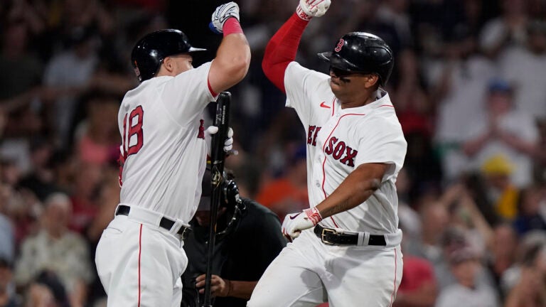 Boston Red Sox's Rafael Devers, right, celebrates with Adam Duvall, left, after scoring on his home run in the seventh inning of a baseball game against the New York Mets, Sunday, July 23, 2023, in Boston. (AP Photo/Steven Senne)