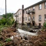 Heavy flooding on a river left damage beside residential and commercial buildings near Main Street, Monday, July 10, 2023, in Highland Falls, New York.