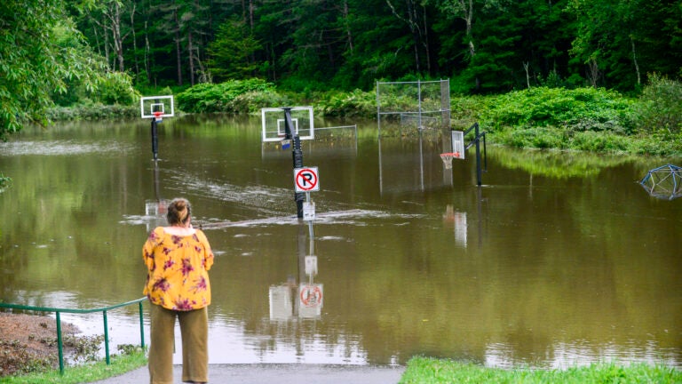 Karen Matter, of Amherst, N.H., takes a video of the flooding from the North Branch Deerfield River.