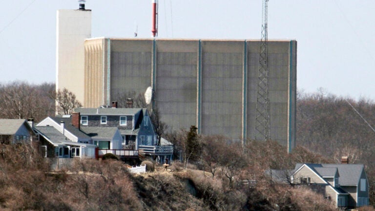 FILE - A portion of the Pilgrim Nuclear Power Station is visible beyond houses along the coast of Cape Cod Bay in Plymouth, Mass., March 30, 2011.