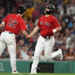 Boston Red Sox's Enrique Hernandez, right, celebrates with Connor Wong (12) after scoring.