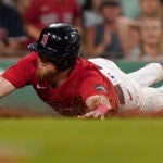 Christian Arroyo of the Red Sox slides home to score on a fielding error in the sixth inning.