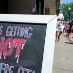 Picture of chalkboard sign that says "It's getting hot out here."