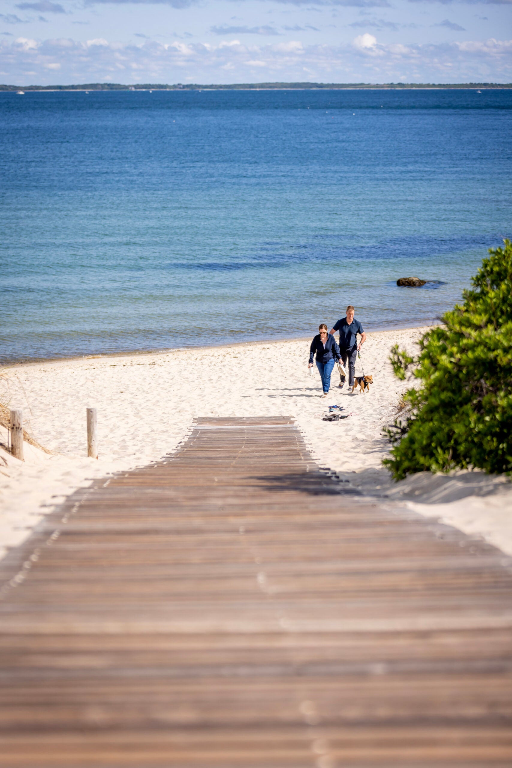 People walk in Lambert’s Cove Beach in West Tisbury on Martha’s Vineyard.