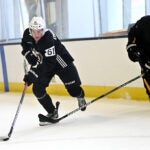 Forward Andre Gasseau, left, fends of a stick from a coach during a drill at Bruins development camp at Warrior Arena.