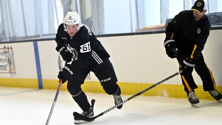 Forward Andre Gasseau, left, fends of a stick from a coach during a drill at Bruins development camp at Warrior Arena.