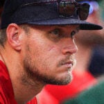 Boston Red Sox pitcher Tanner Houck (89), with only a small scar showing on his cheek, watches from the dugout during the eighth inning.