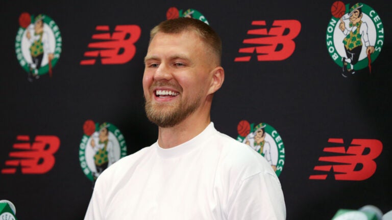 Newly acquired big man Kristaps Porzingis s all smiles after getting gets his new Celtics Jersey at a afternoon press-conference.