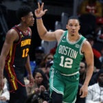 The Celtics Grant Williams is pictured as he flashes three fingers after hitting a three point shot.