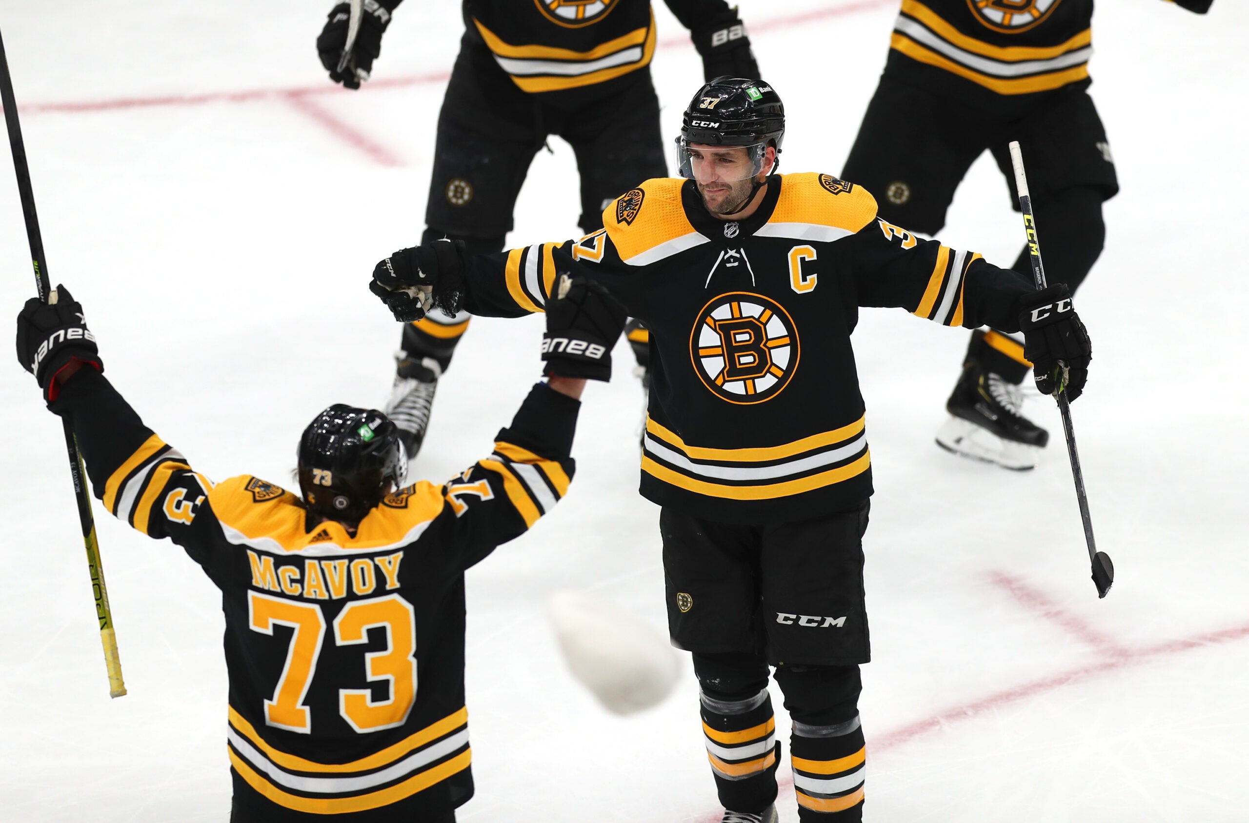 Boston Bruins center Patrice Bergeron (37) celebrates his hat trick goal in the 3rd period with Boston Bruins defenseman Charlie McAvoy (73), his 400th career goal.