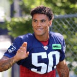 The Patriots held their third day of their training camp at the Gillette Stadium practice fields. Christian Gonzalez waves to fans as he arrives on the field.