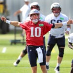 Patriots QB Mac Jones stretches with the team at the start of the first workouts at the Patriots training camp at Gillette Stadium.