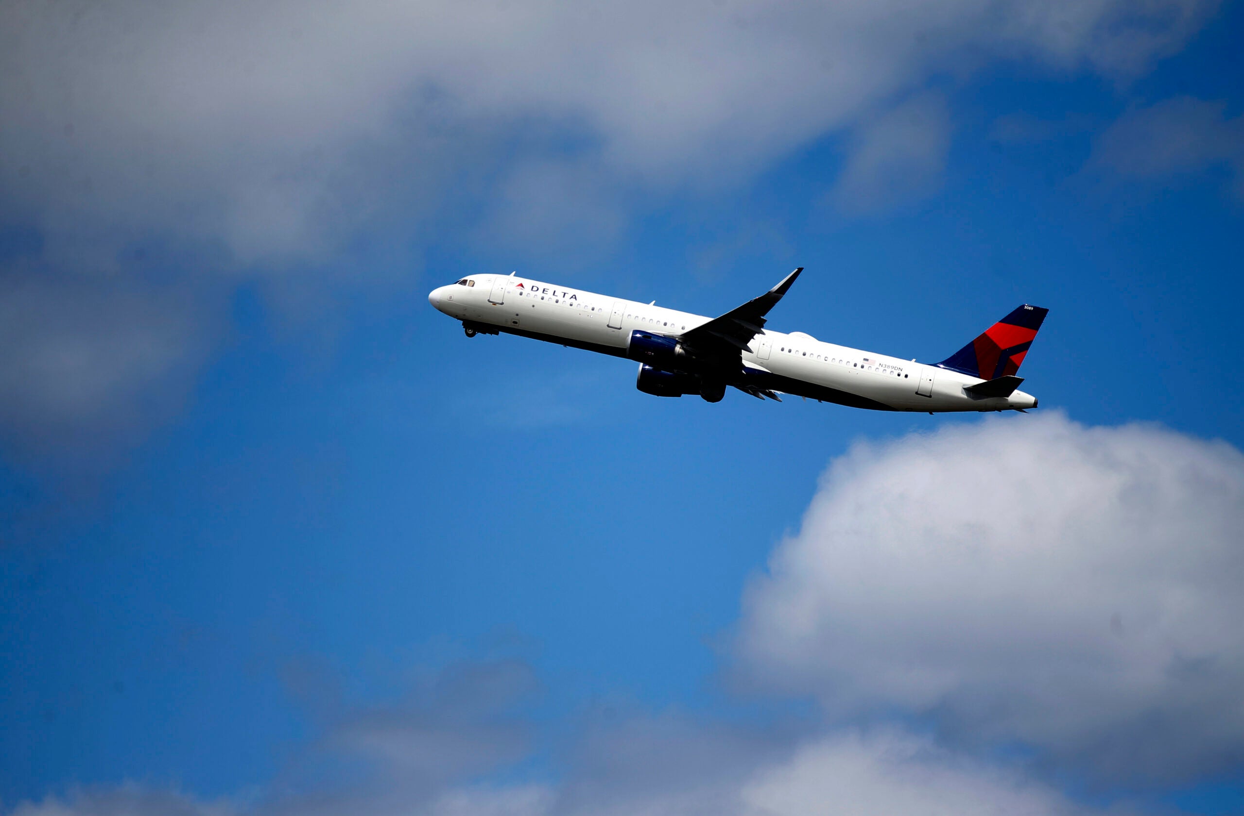A Delta Air Lines jet takes off into the clouds.