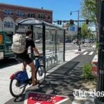 A cyclist travels down a separated bike lane in Cambridge's Inman Square.