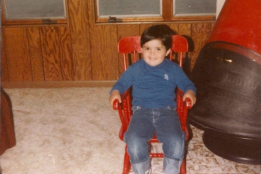 Jimmy Thyden as a child sitting in a red chair. 