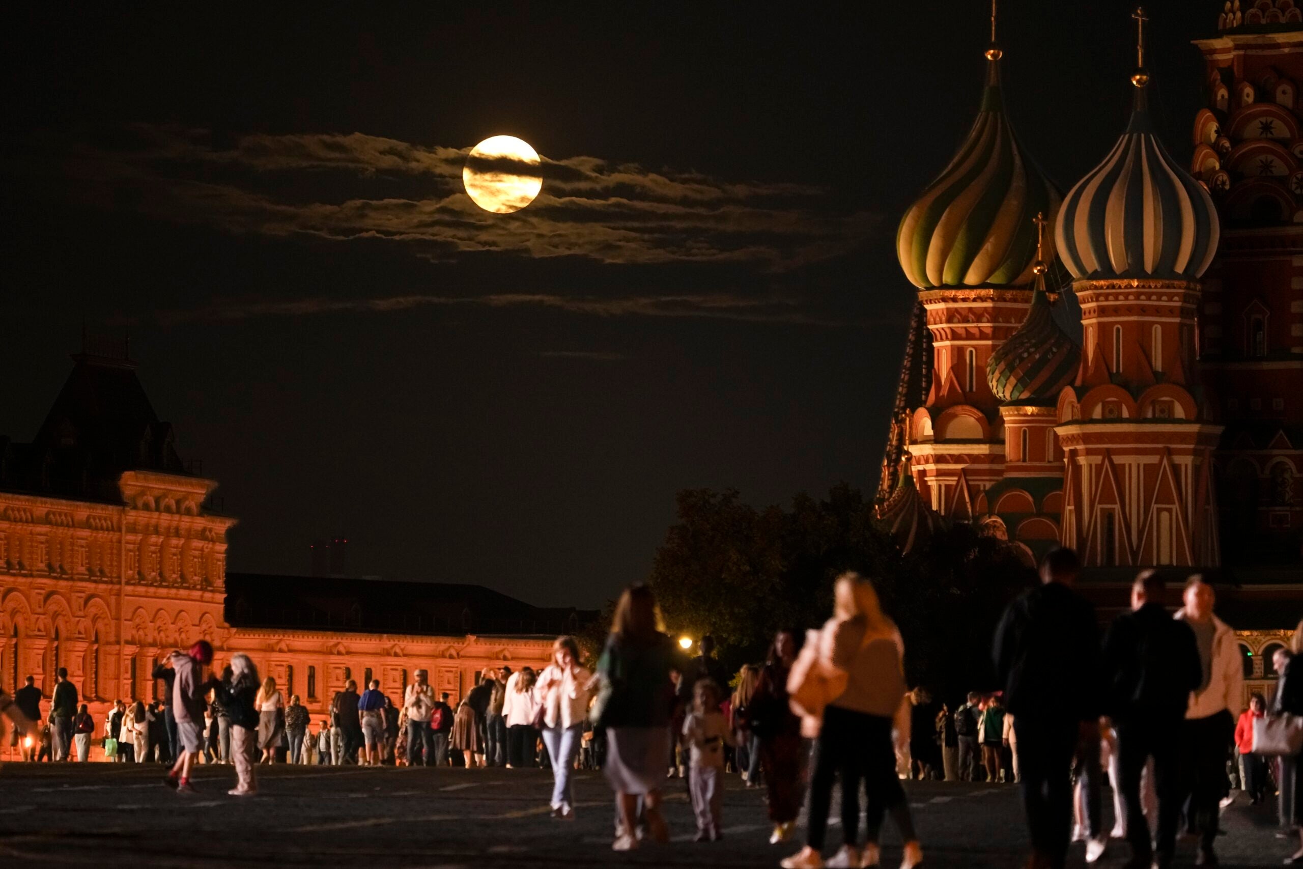The August Super Blue Moon sets behind a historical building and the St. Basil's Cathedral in Moscow. 