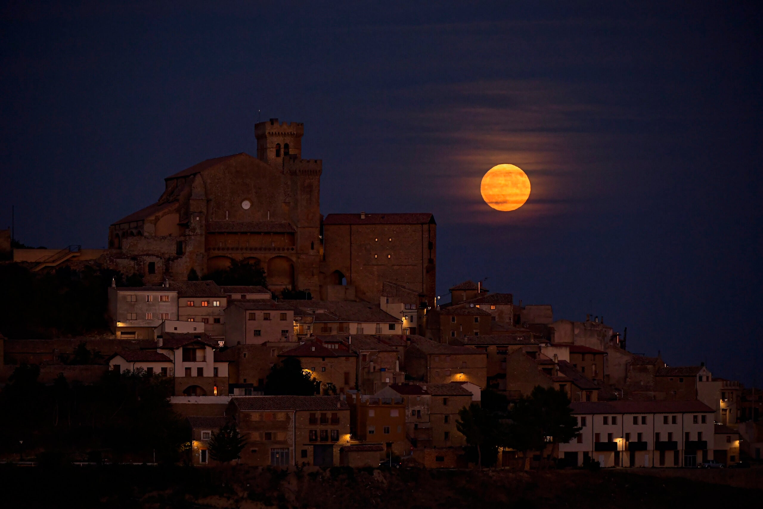 The moon known as blue moon rises behind the small village of Ujue.